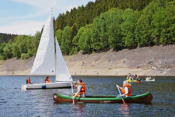 Menschen segeln in kleinen Booten auf einem See