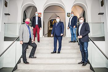 Menschen mit Masken stehen auf einer Treppe 