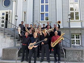 Personen mit Musikinstrumenten stehen auf einer Treppe 