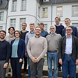 Menschen stehen auf einer Treppe vor einem Gebäude