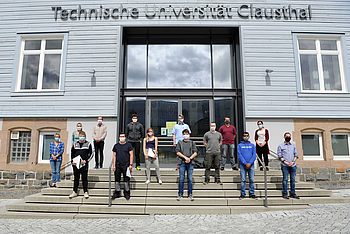 Studierende stehen auf der Treppe vor dem Eingang zum Hauptgebäude der TU Clausthal