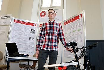 Person neben einem Fahrrad und einem Laptop