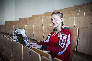 Eine Person im Hörsaal mit einem Laptop und Rollschuhen