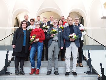 Menschen mit Blumen stehen auf einer Treppe